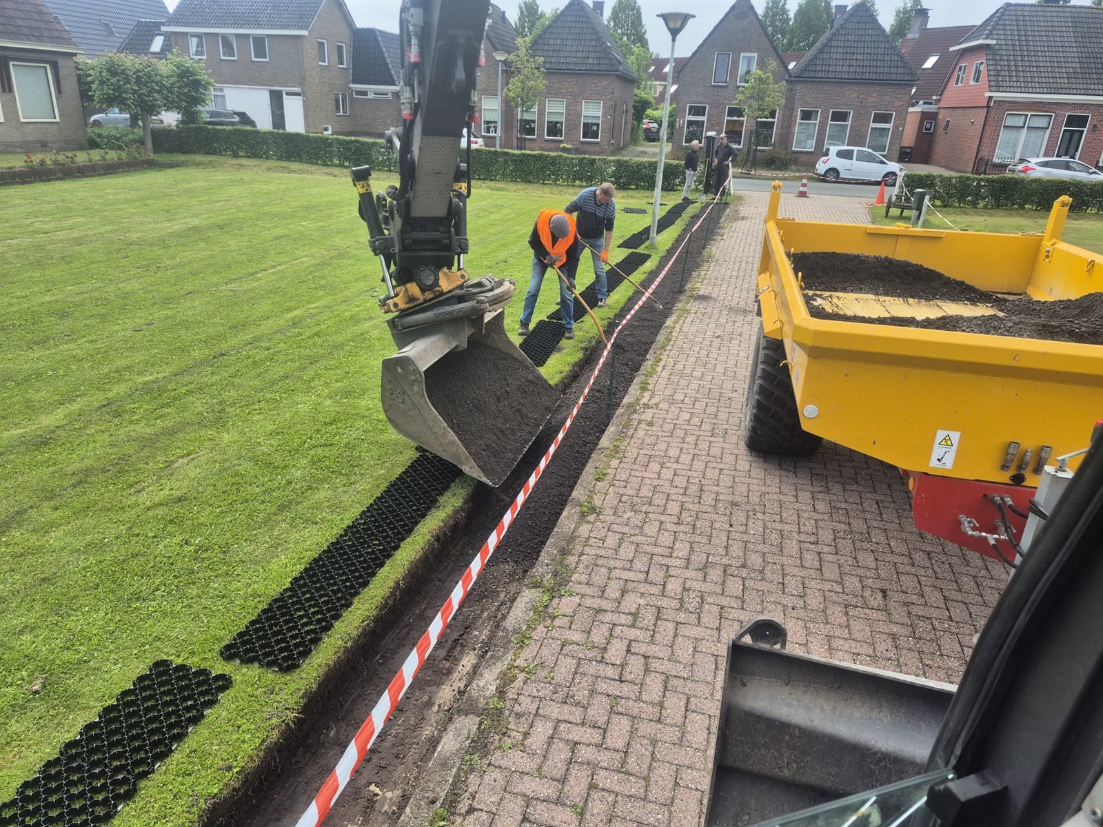 Aanleg van grasbetontegels langs een straat