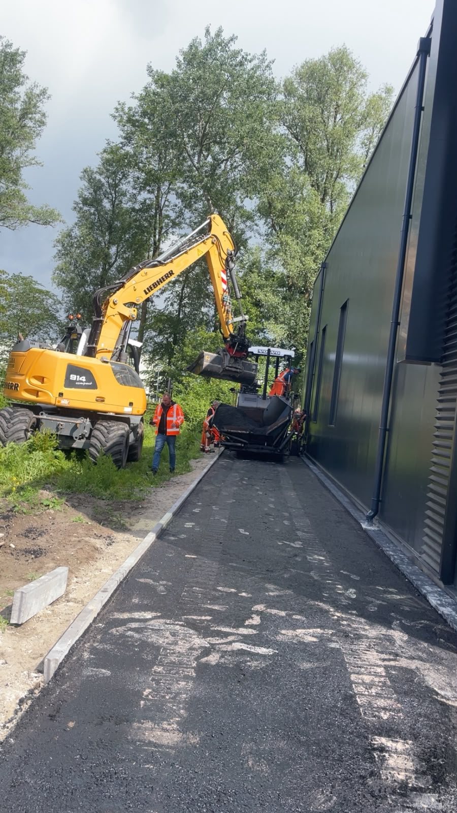 Asfalt aanleggen van een toegangspad langs het pand