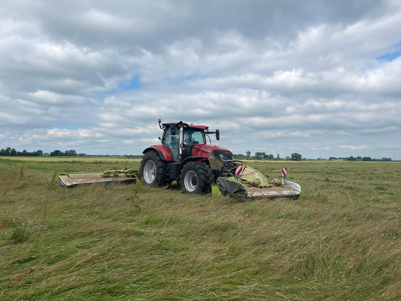 Tractor maait gras met een triple maaier
