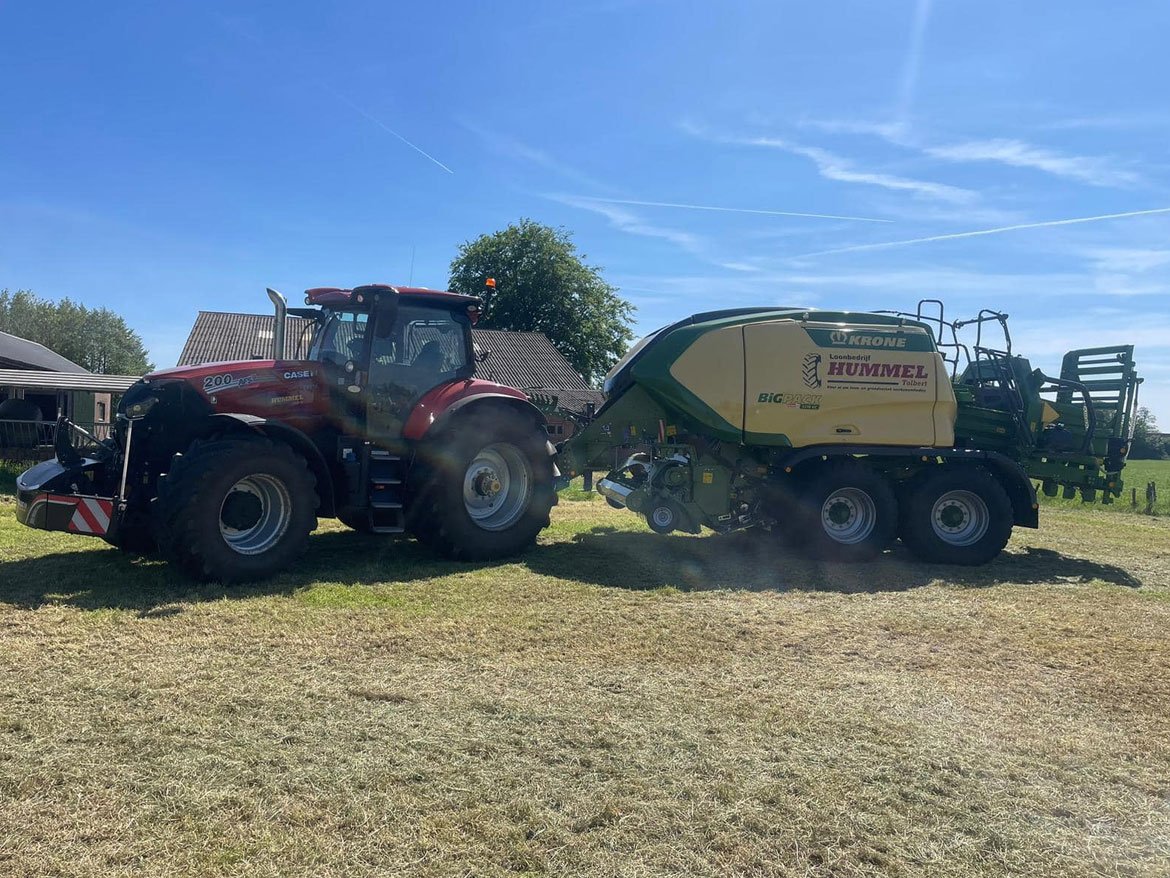 Tractor met de Krone BiG Pack grootpakpers op het land