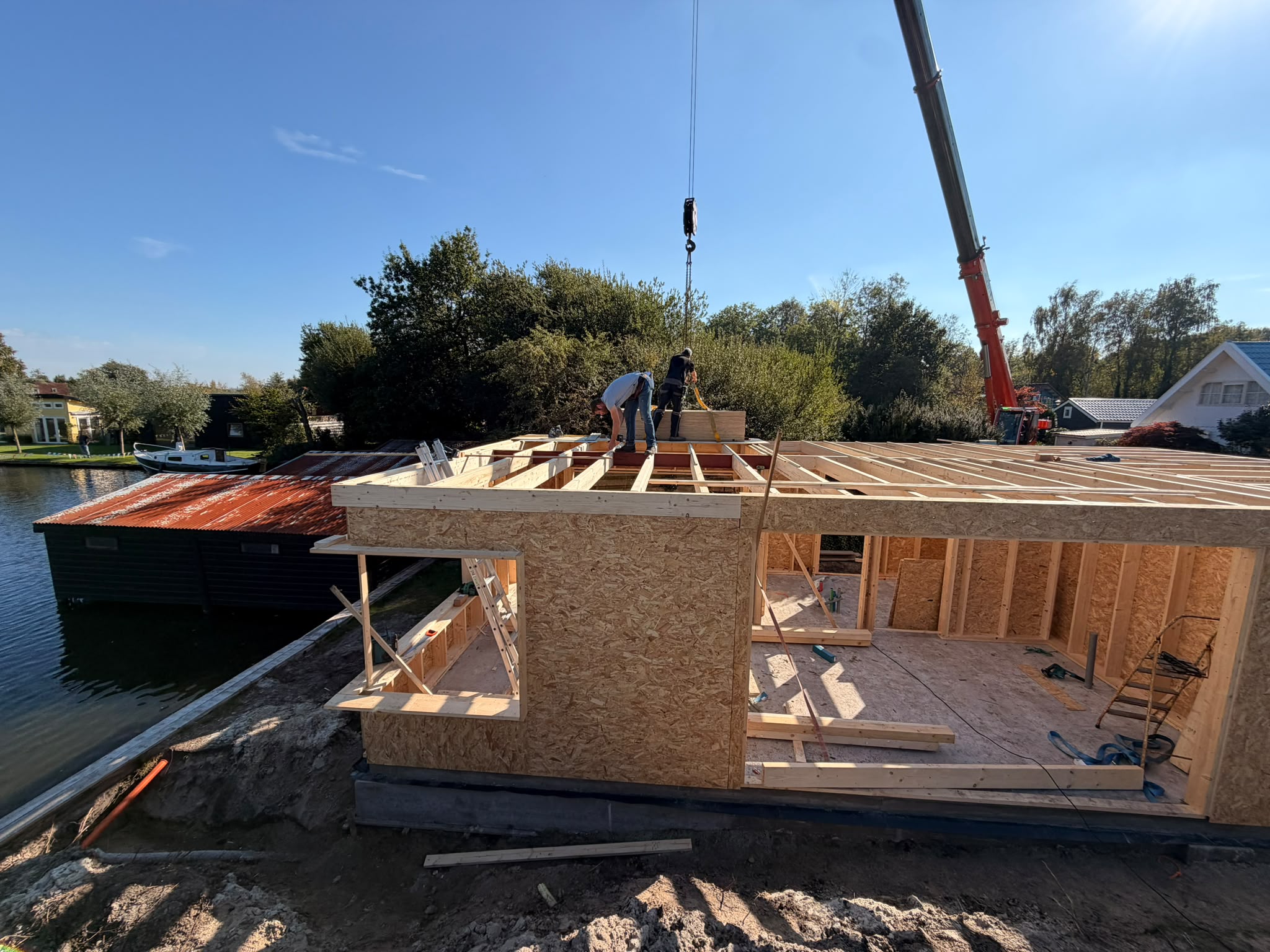 De vakantiewoning in aanbouw direct aan het Paterswoldsemeer, met de mobiele kraan boven de dakconstructie